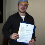 Steen Fredrickson holds up his signed National Letter of Intent to play baseball at Montana State University Billings